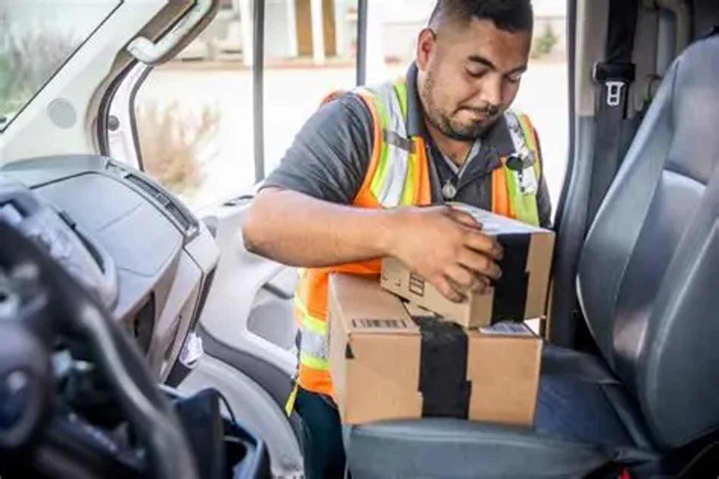 Delivery driver sorting parcels inside a delivery van