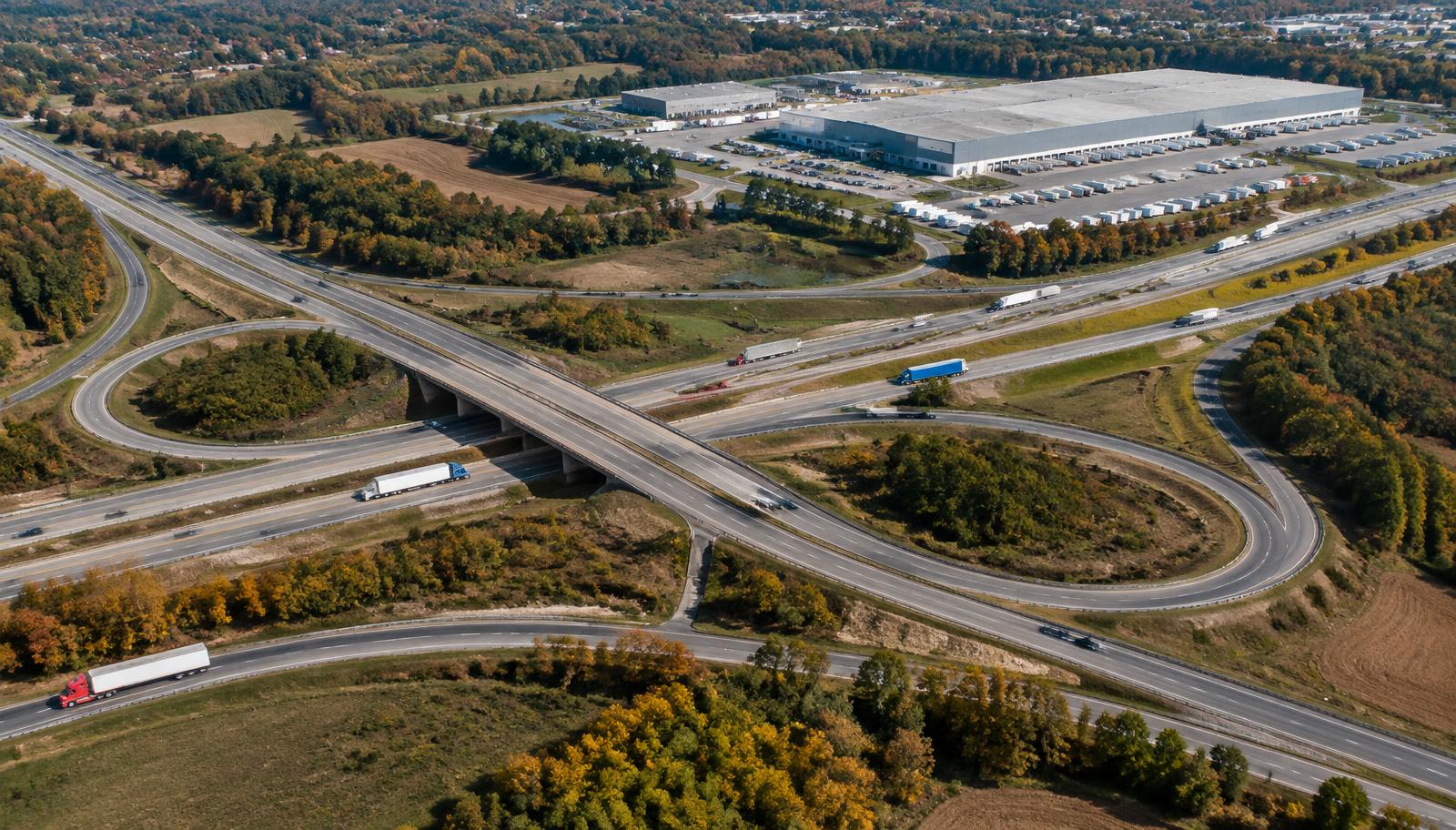 Aerial view of trucks on a Mid-Atlantic highway interchange beside a distribution center